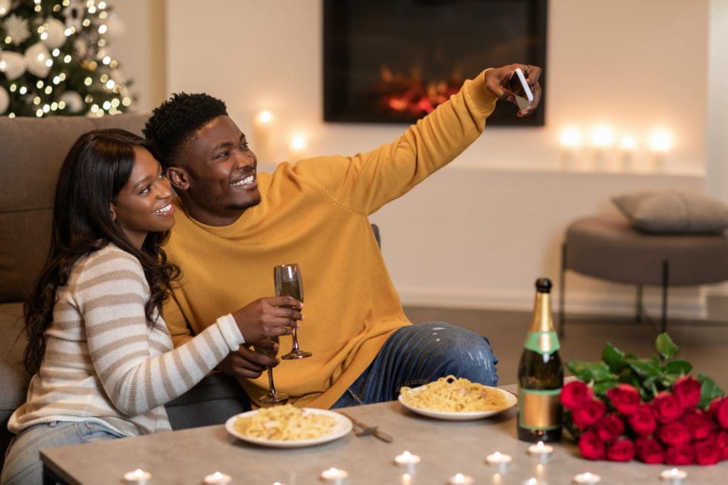 Black Couple Making Selfie On Smartphone Celebrating Valentine At Home