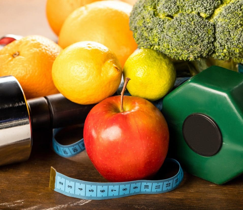 close up view of healthy food, measuring tape and dumbbells, healthy living concept