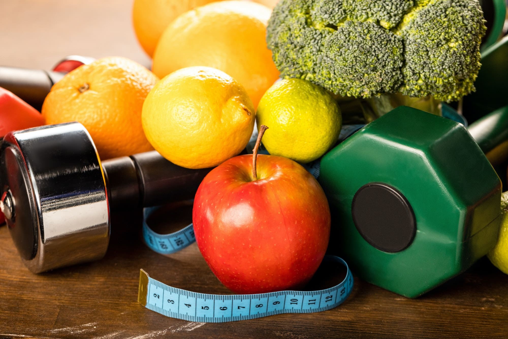close up view of healthy food, measuring tape and dumbbells, healthy living concept