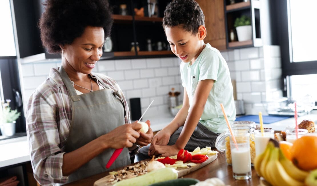 Mother and child having fun preparing healthy food in kitchen