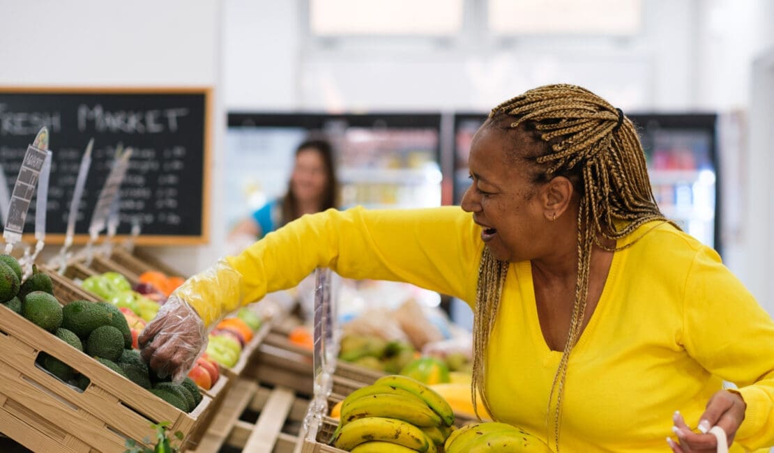 Middle-aged woman with braids buying healthy food at the local market