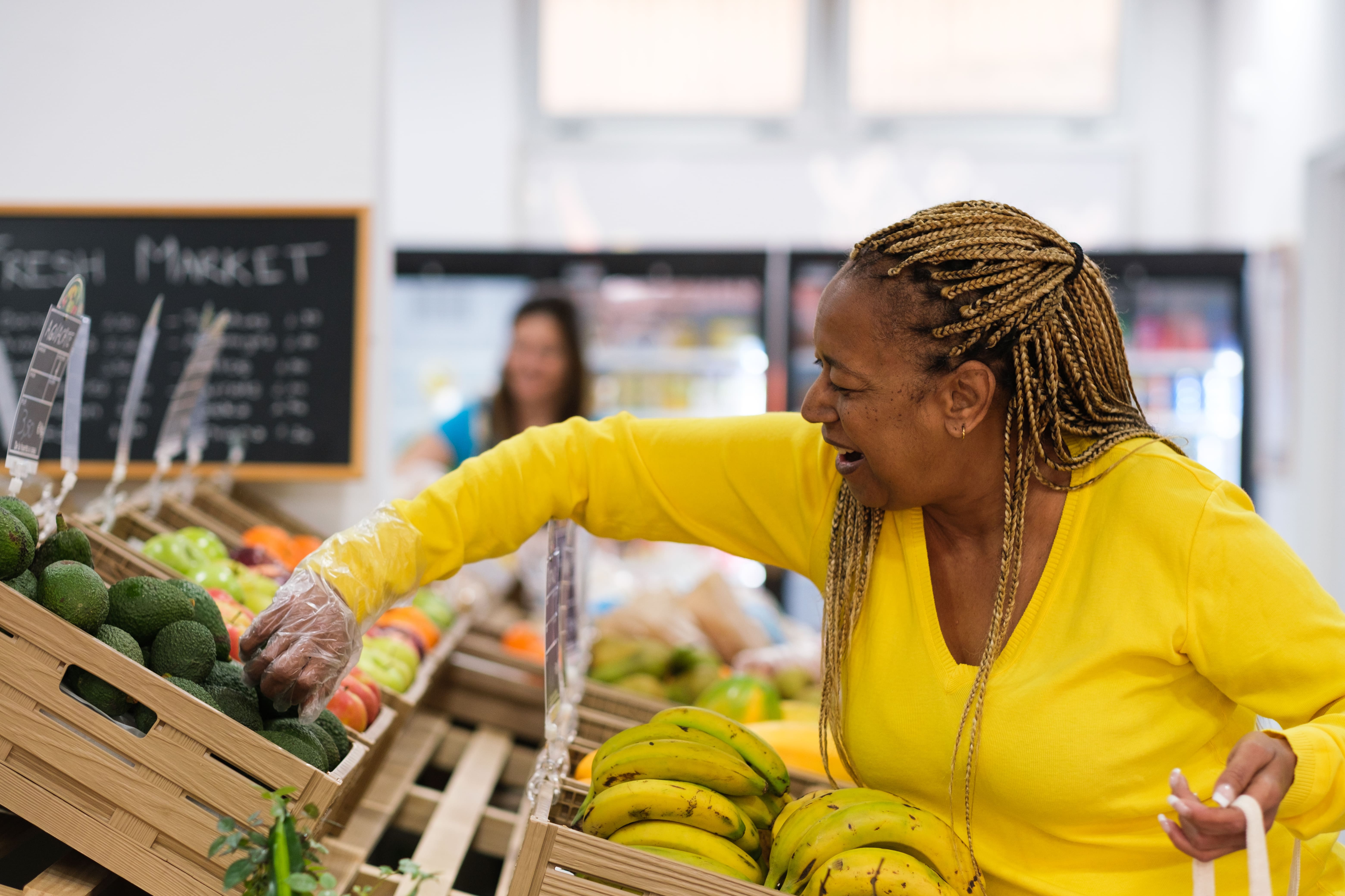 Middle-aged woman with braids buying healthy food at the local market