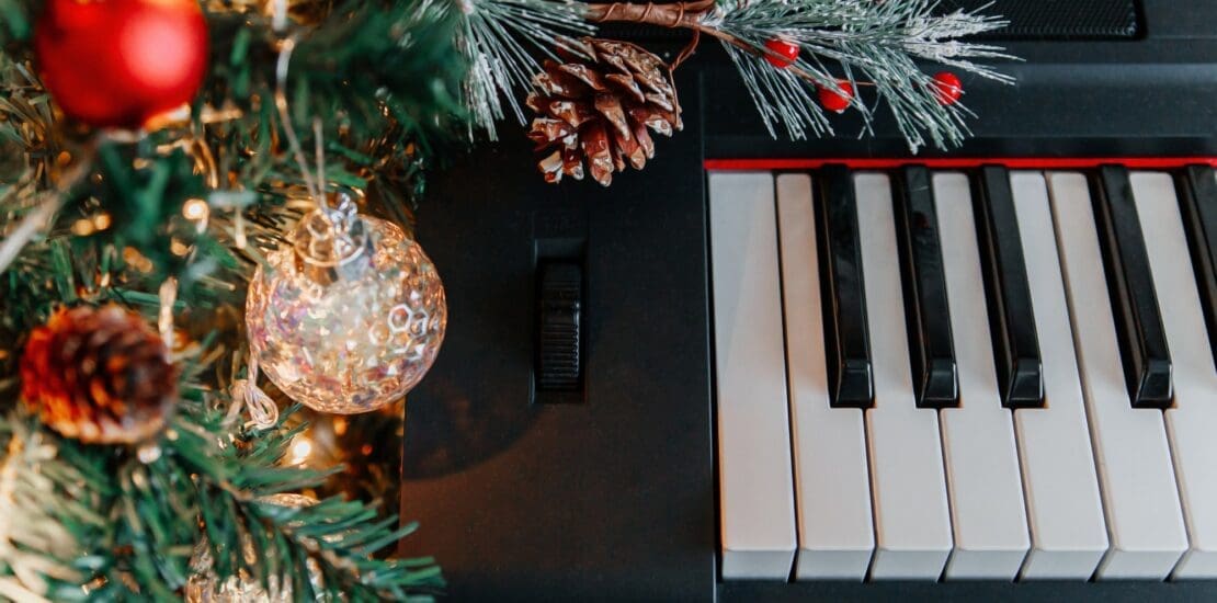 branches of a decorated Christmas tree on the background of piano keys.