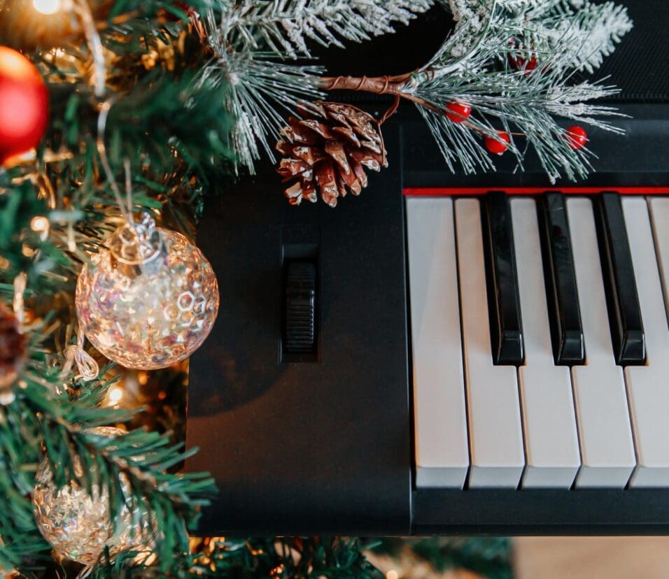 branches of a decorated Christmas tree on the background of piano keys.
