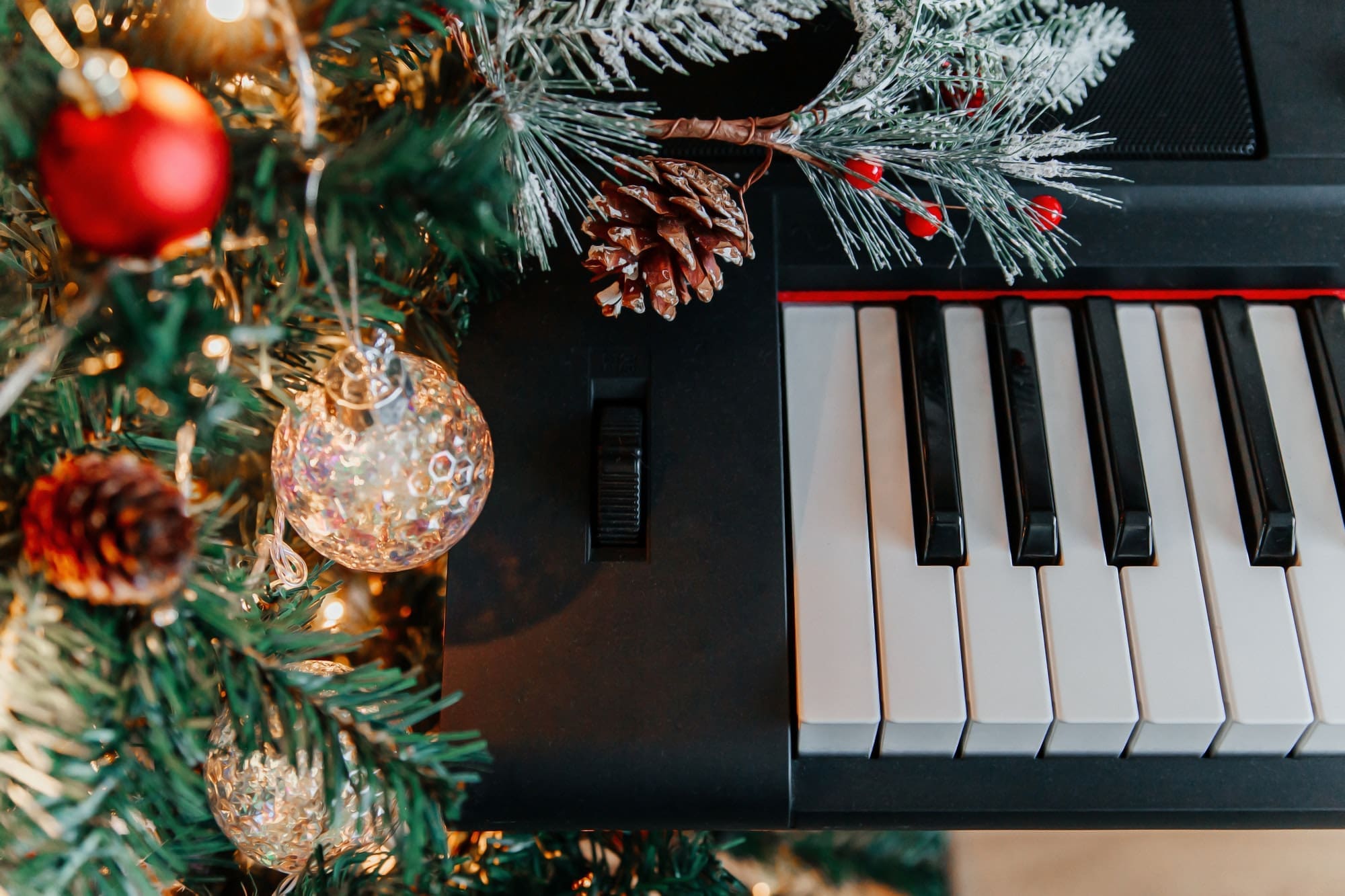 branches of a decorated Christmas tree on the background of piano keys.