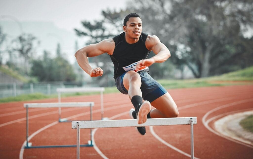 Full length shot of a handsome young male athlete practicing hurdles on an outdoor track
