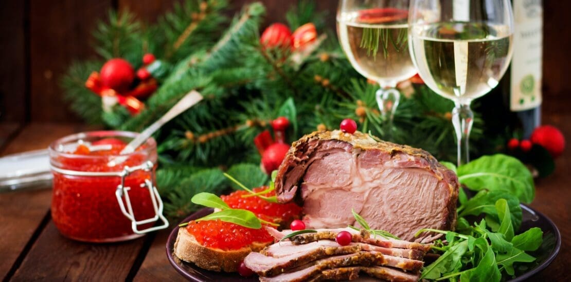 Christmas baked ham and red caviar, served on the old wooden table.