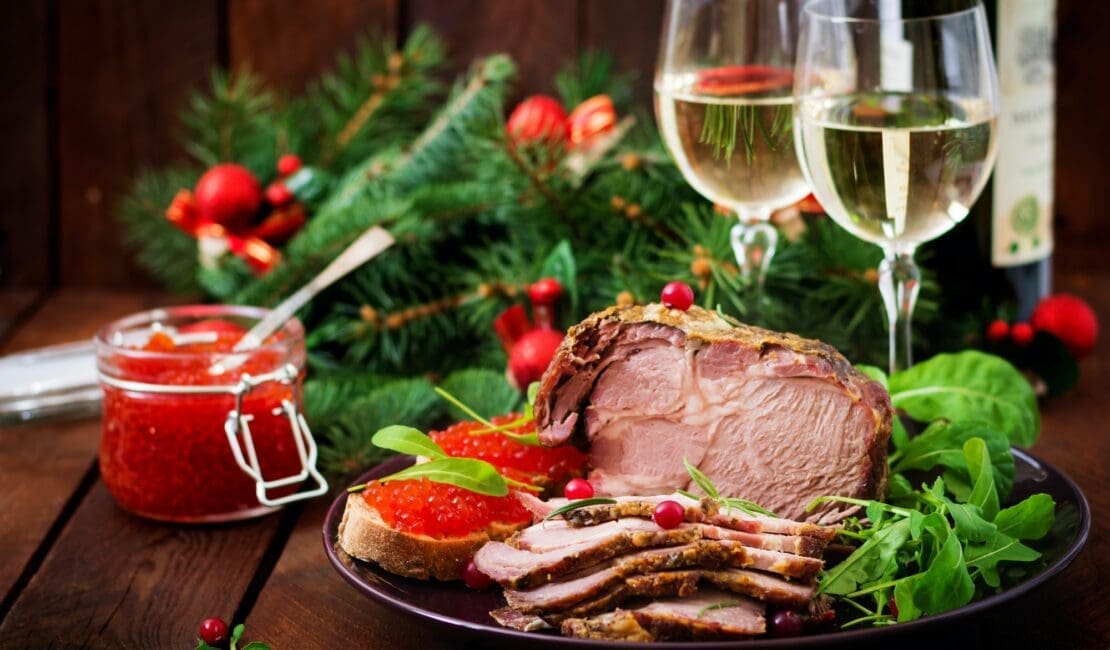 Christmas baked ham and red caviar, served on the old wooden table.